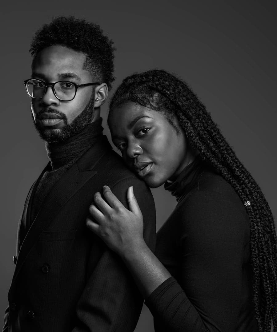 A couple in black, her head resting on his shoulder