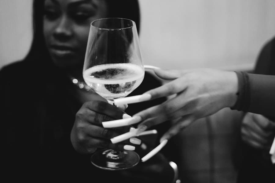 Two people’s hands holding wine glasses across a table