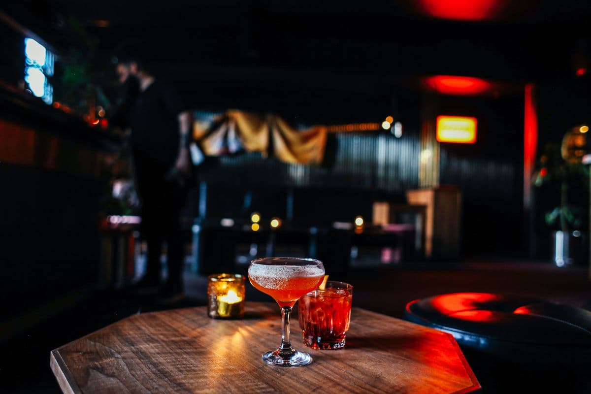 Two cocktails beside a candle
